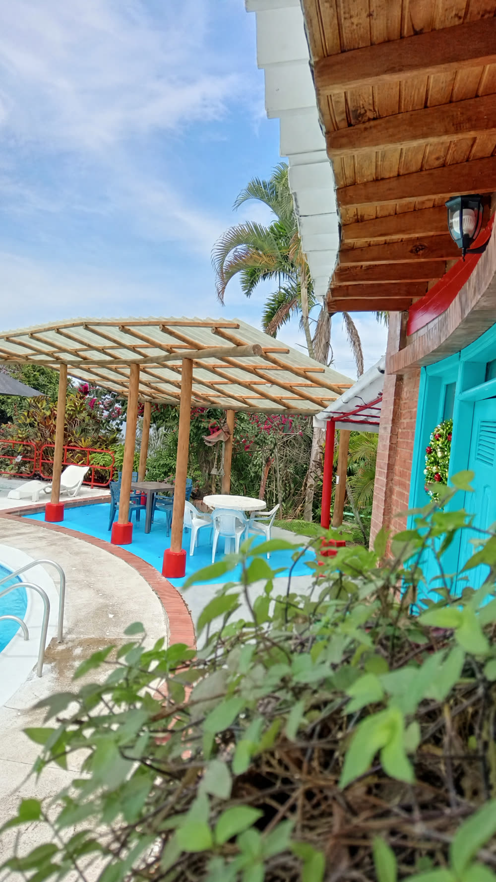 Pérgola y piscina entre jardines del Hotel El Bohío para pasadía